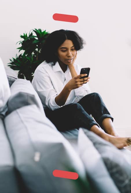 Woman on couch checking smartphone